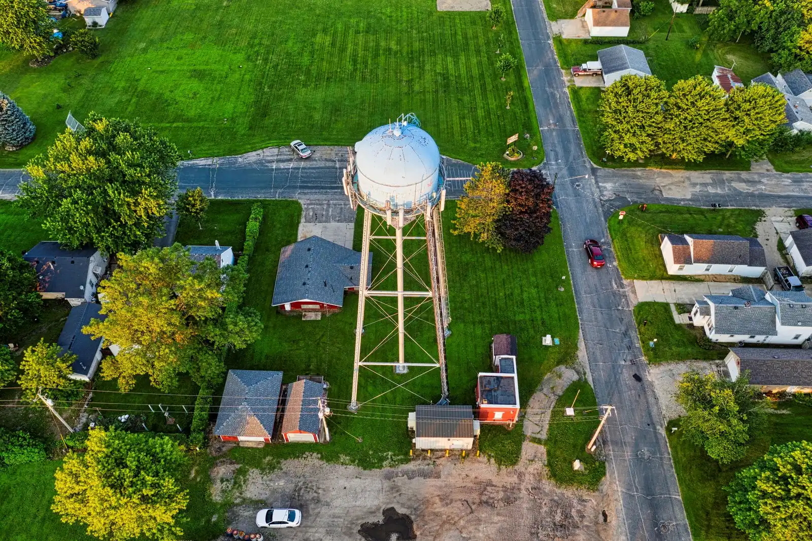 Aerial view of a small American town with a water tower at dusk