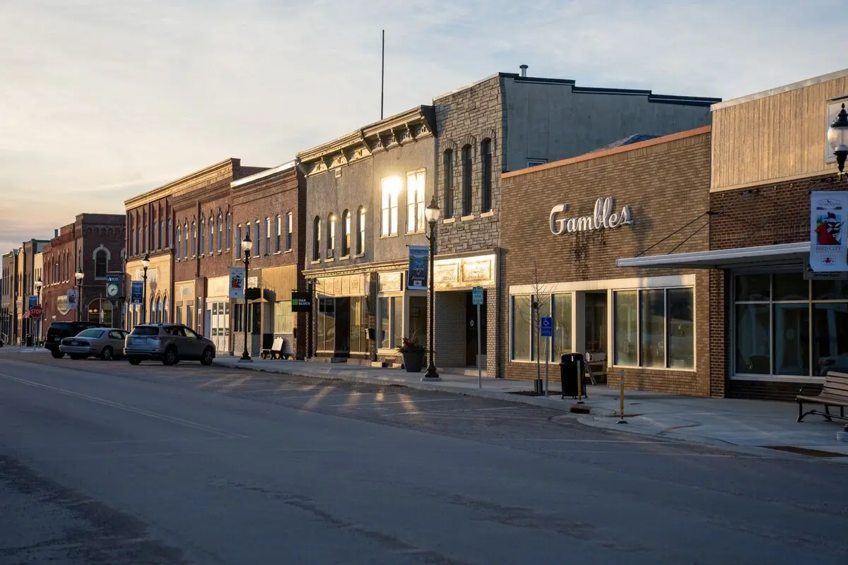 Brick storefronts on a small-town main street at golden hour